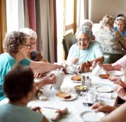 Groupe de personnes âgées qui prennent leur repas en maison de retraite