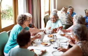 Groupe de personnes âgées qui prennent leur repas en maison de retraite